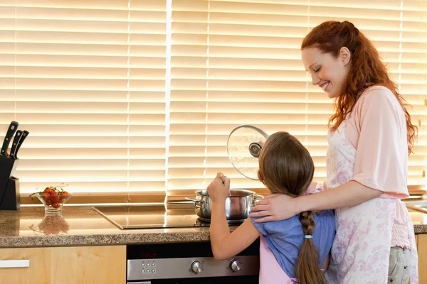 Alegre madre enseñando a su hija a cocinar — Foto de Stock