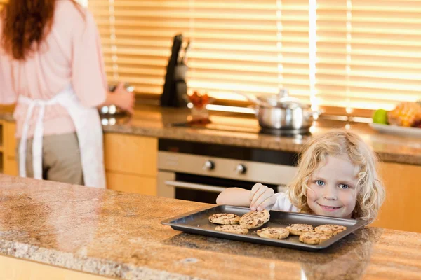 Мальчик крадет печенье, пока его мать не смотрит — стоковое фото