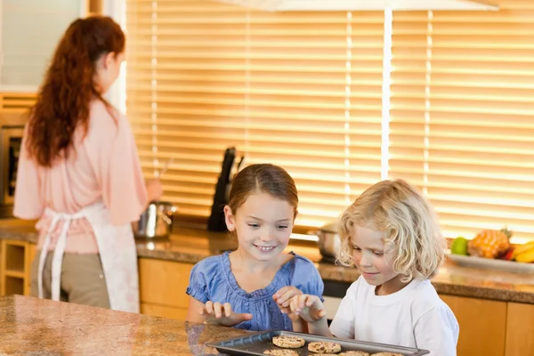 Siblings stealing cookies together — Stock Photo, Image