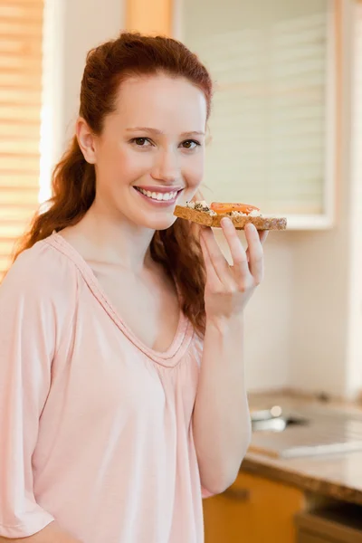 Smiling woman holding slice of bread — Stock Photo, Image
