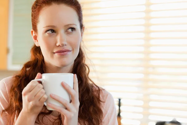 Woman with a cup in thoughts — Stock Photo, Image