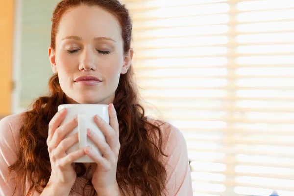Woman enjoys the smell of her coffee — Stock Photo, Image