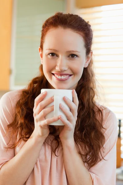 Улыбающаяся женщина с чашкой кофе — стоковое фото