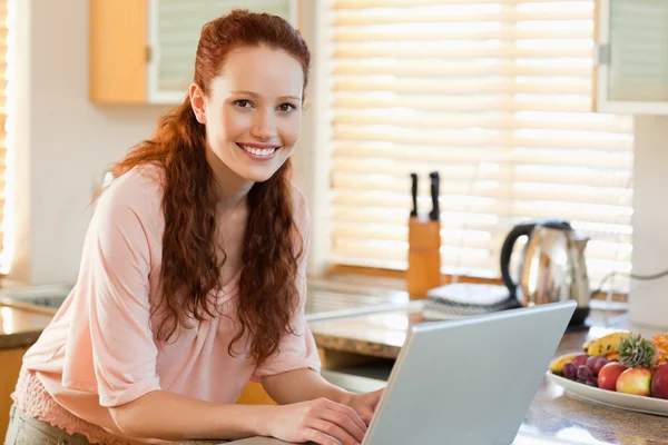 Nő rajta laptop használ a konyhában — Stock Fotó