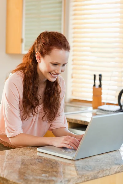 Woman using her notebook in the kitchen — Stock Photo, Image