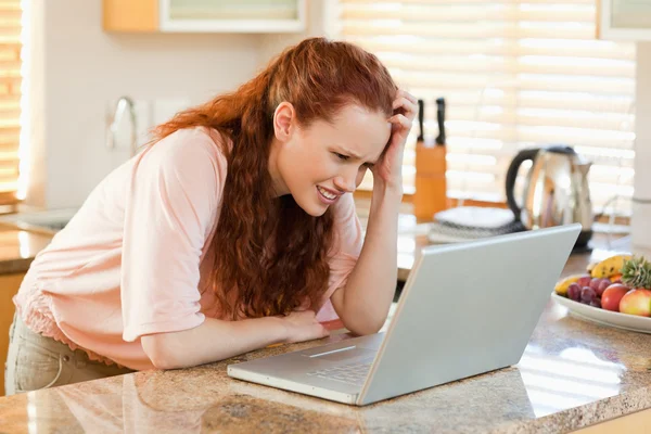 Женщина в замешательстве смотрит на свой ноутбук — стоковое фото