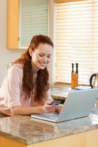 Woman shopping online in the kitchen — Stock Photo, Image