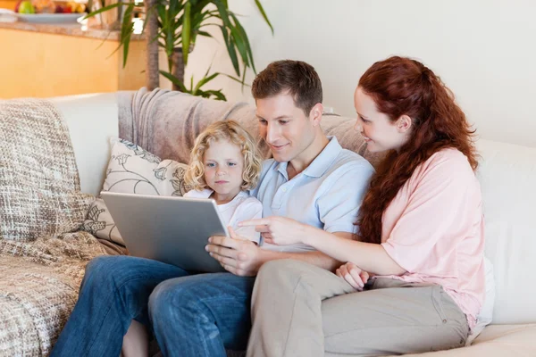 Rodzina korzysta z laptopa na kanapie — Zdjęcie stockowe
