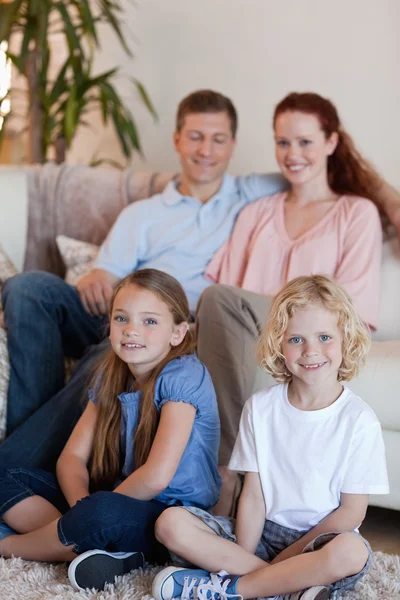 Zittend in de woonkamer en gelukkige familie — Stockfoto