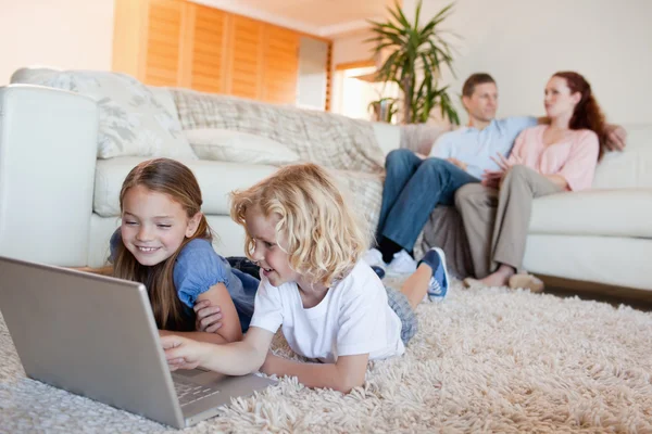 Broers en zussen met behulp van laptop in de woonkamer — Stockfoto