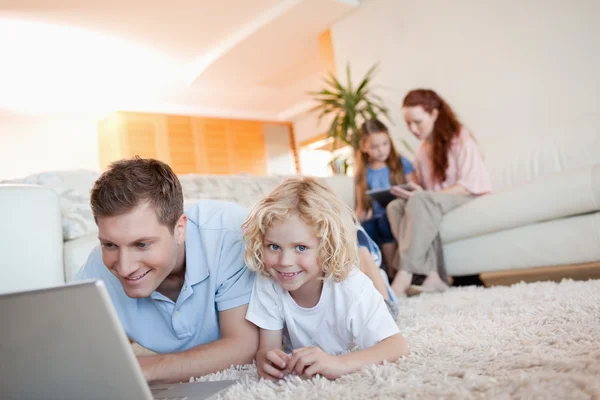 Father and son with laptop on the floor — Stock Photo, Image