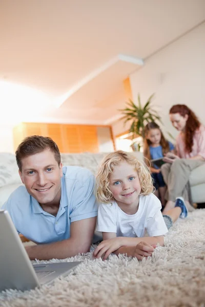 Pai e filho usando internet no chão — Fotografia de Stock
