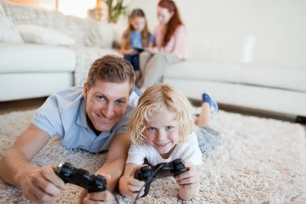 Отец и сын в гостиной играют в видеоигры — стоковое фото
