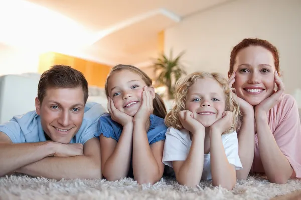 Familia alegre en la alfombra —  Fotos de Stock