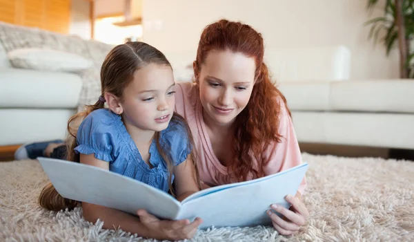 Madre e figlia guardando una rivista — Foto Stock