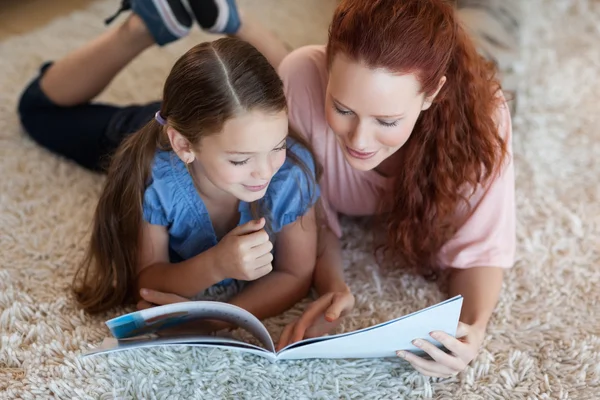 Mutter und Tochter auf dem Teppich beim Lesen — Stockfoto