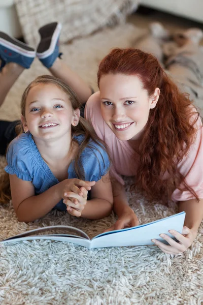 Mãe e filha no chão leitura — Fotografia de Stock