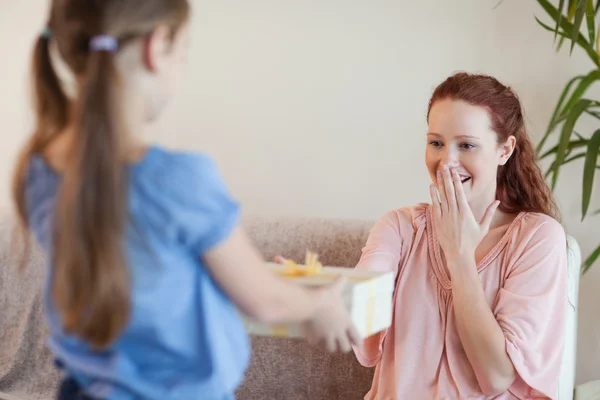 Mother being surprised by daughter with present — Stock Photo, Image