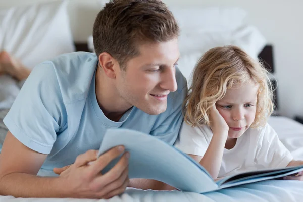 父亲和儿子读一本杂志 — 图库照片