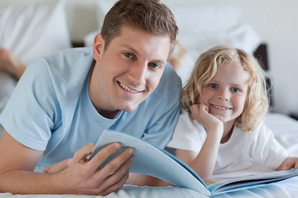 Father and son looking at magazine — Stock Photo, Image