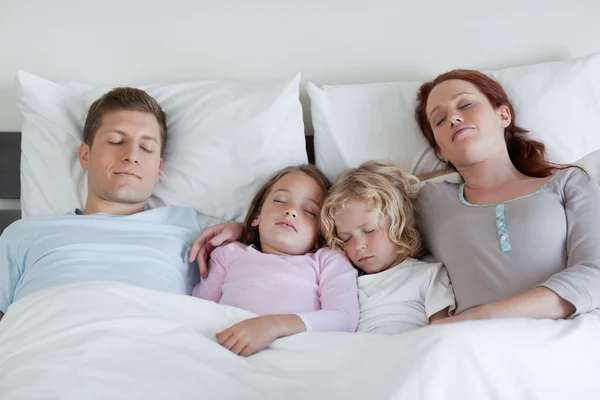 Семья спит в кровати вместе — стоковое фото