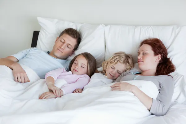 Очаровательная семья, спящая вместе. — стоковое фото