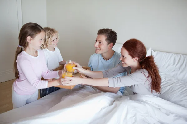 Children surprising their parents with breakfast — Stock Photo, Image