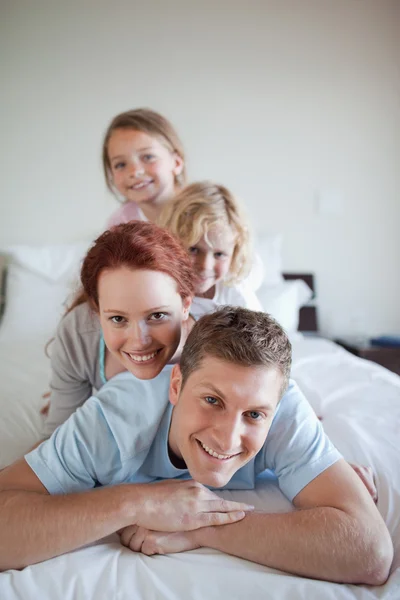 Yatakta birlikte eğlenceli aile — Stok fotoğraf