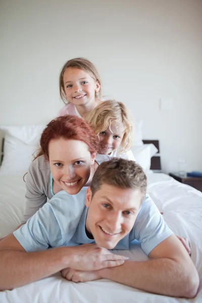 Игривая семья, лежащая друг на друге — стоковое фото