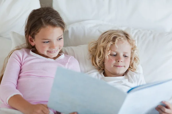 Bror och syster läser bed tid berättelse — Stockfoto
