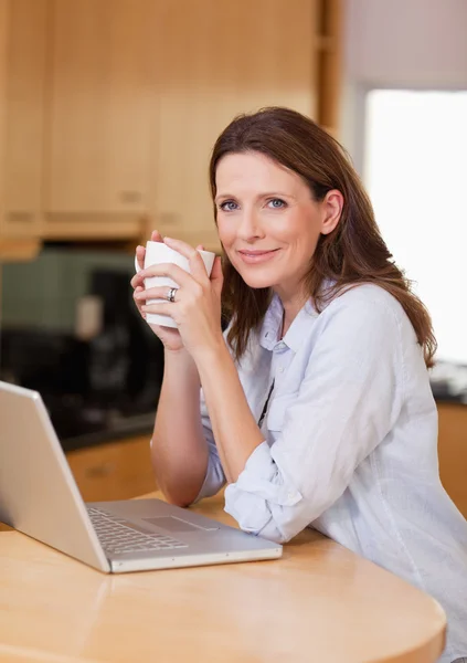 Woman with laptop and a cup — Stock Photo, Image