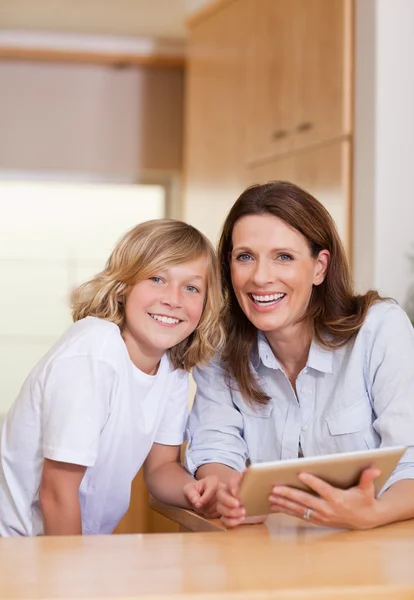 Woman and her son using tablet in the kitchen — Stock Photo, Image