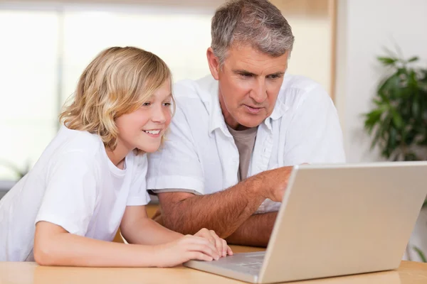 父亲和儿子在厨房中使用笔记本电脑 — 图库照片