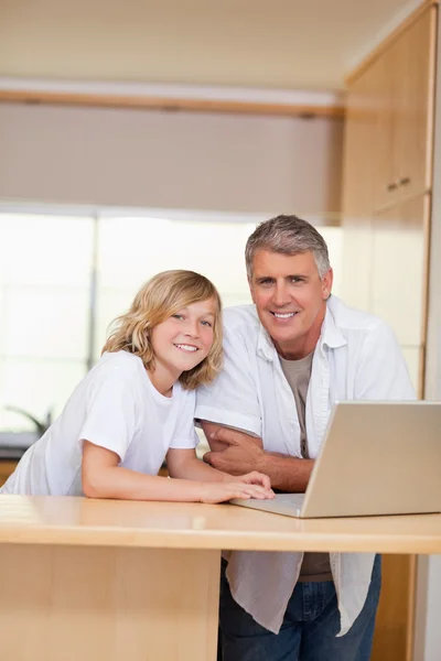Far och son med laptop i köket — Stockfoto