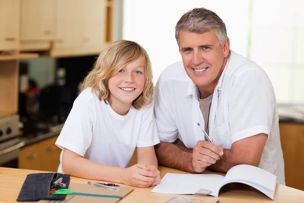 Чоловік допомагає синові з домашнім завданням — стокове фото