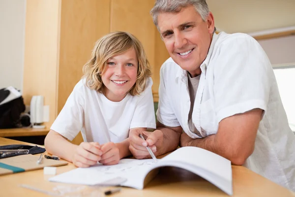 Padre ayudando a su hijo con su tarea — Foto de Stock