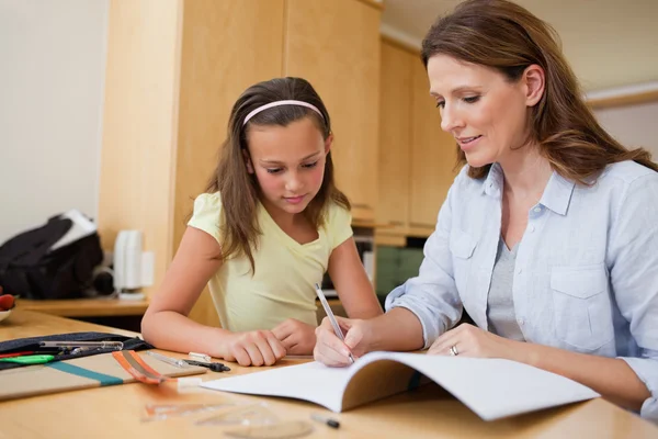 Mutter hilft Tochter bei den Hausaufgaben — Stockfoto