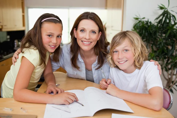 Moeder haar kinderen helpen met huiswerk — Stockfoto