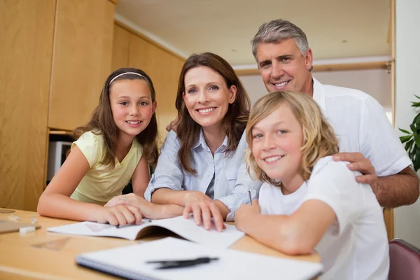 Föräldrar att hjälpa sina barn med läxor — Stockfoto