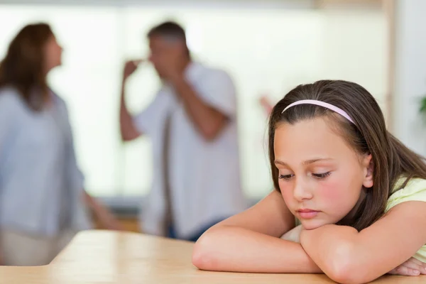 Ledsen tjej med föräldrarna kämpar bakom henne — Stockfoto