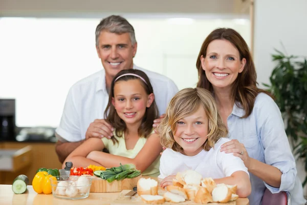 Smiling family making sandwiches — Stock Photo, Image