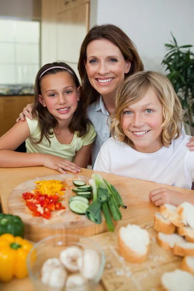 Smiling mother making sandwiches with her children — Stock Photo, Image