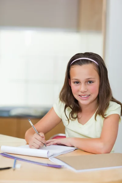 Sorrindo menina fazendo lição de casa — Fotografia de Stock