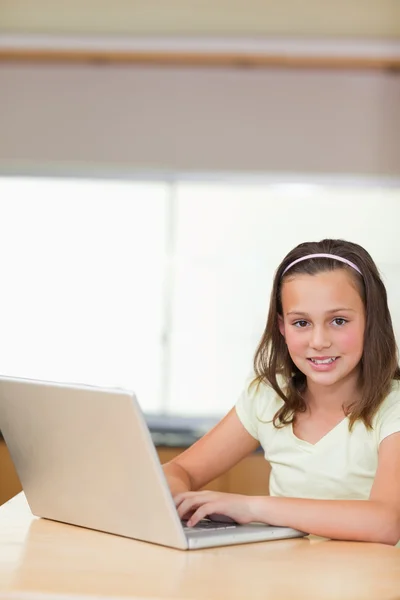 Menina usando laptop na cozinha — Fotografia de Stock