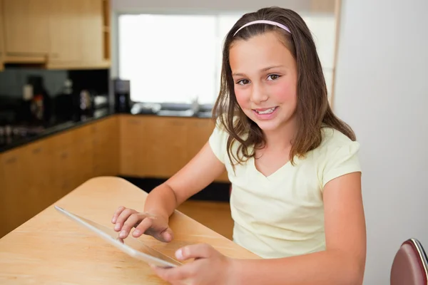 Menina com tablet na mesa da cozinha — Fotografia de Stock
