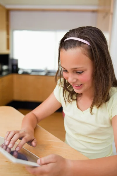 Menina usando tablet na mesa da cozinha — Fotografia de Stock