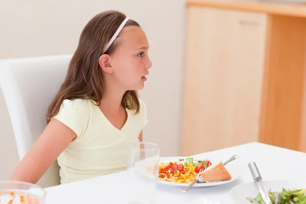 Menina com jantar na mesa — Fotografia de Stock