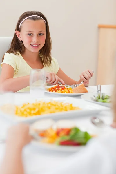 Menina feliz jantando na mesa de jantar — Fotografia de Stock