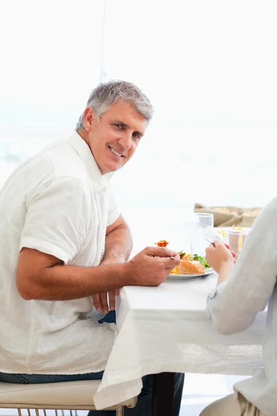 Вид сбоку улыбающегося человека, обедающего — стоковое фото