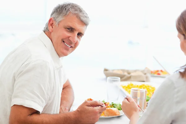 Vista laterale di felice uomo sorridente durante la cena — Foto Stock